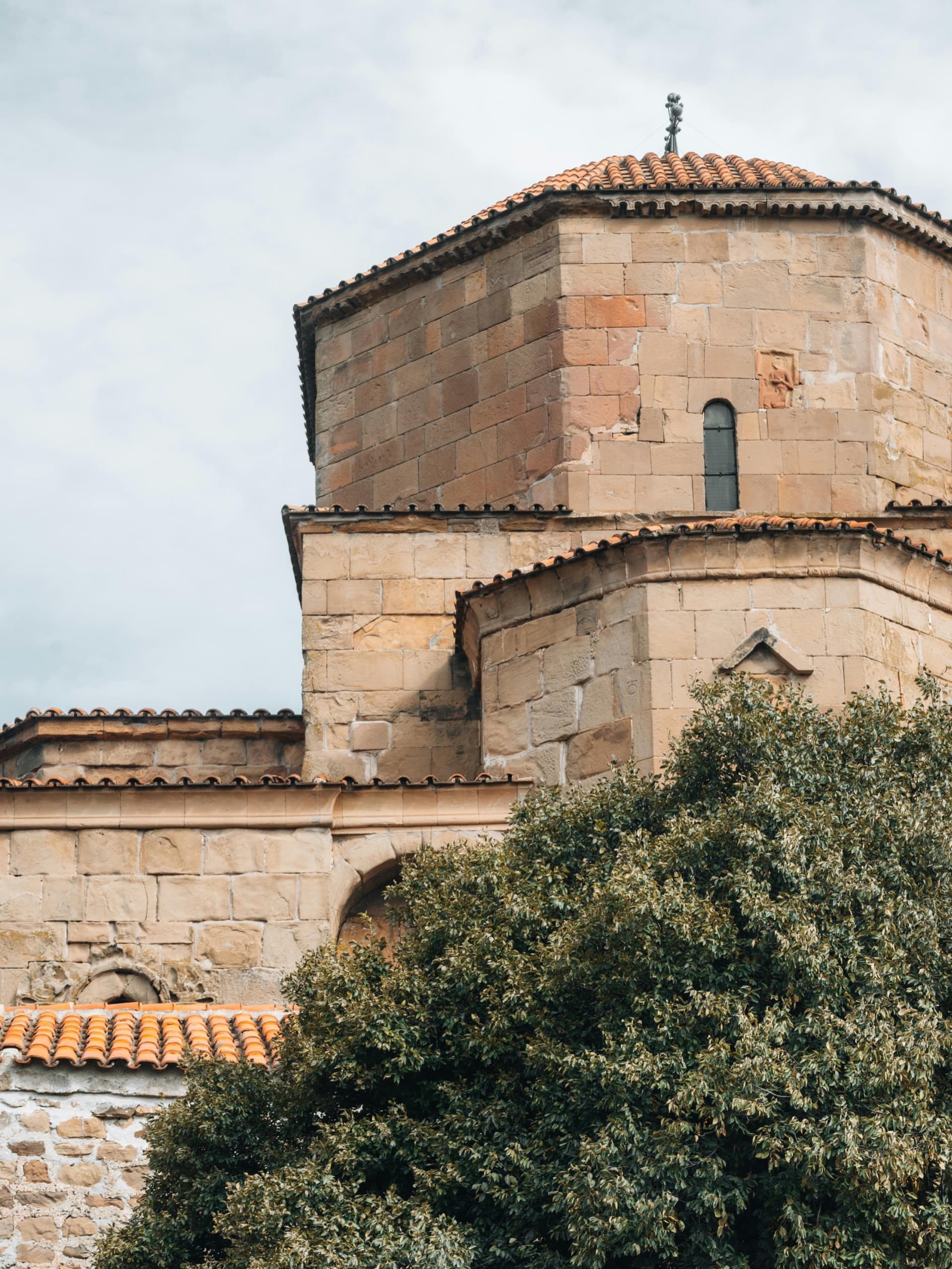 Historic Jvari Monastery with traditional Georgian stone architecture and distinctive red tile roof in Mtskheta