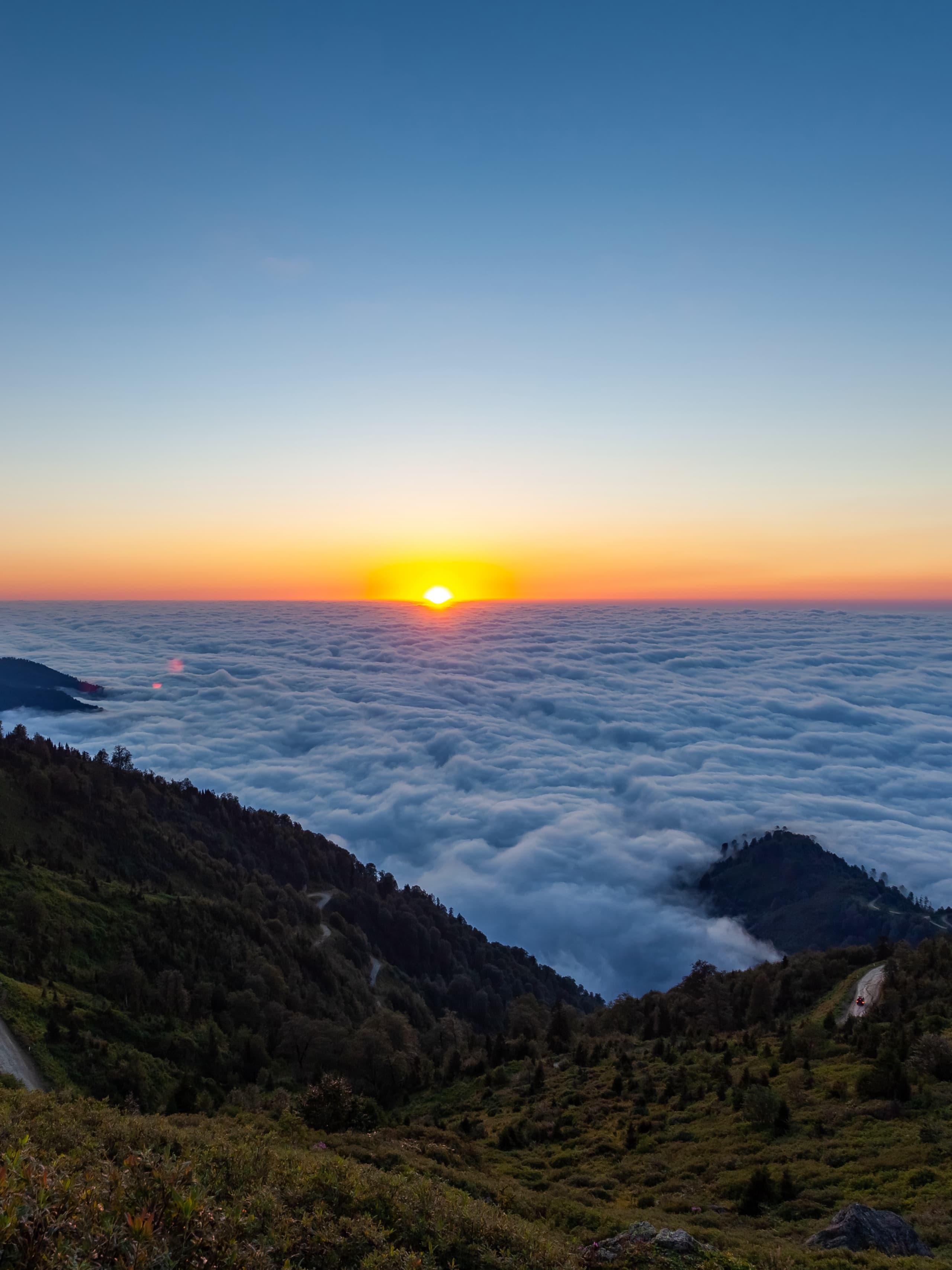 Spectacular sunset view above sea of clouds from Gomis Mta peak in Guria region with mountain silhouettes